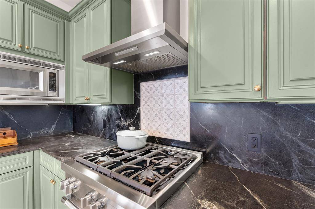 The cabinets are newly painted a lovely shade of sage.  The kitchen is also highlighted by a porcelain tile backsplash accent and Thermador star-shaped burners.