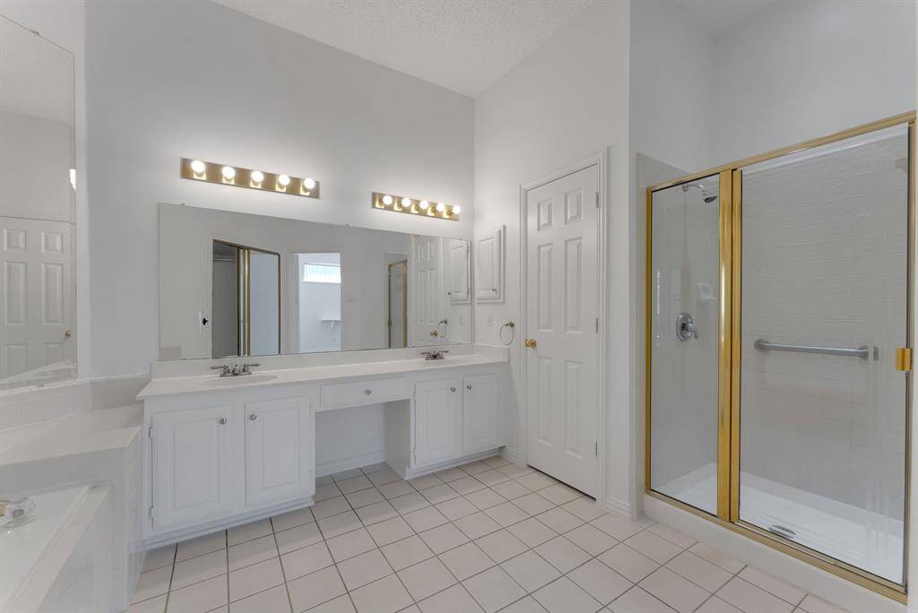 Charming brick home with large windows and a welcoming entrance, nestled between mature trees and well-maintained landscaping. Ideal for those seeking a blend of natural beauty and curb appeal.