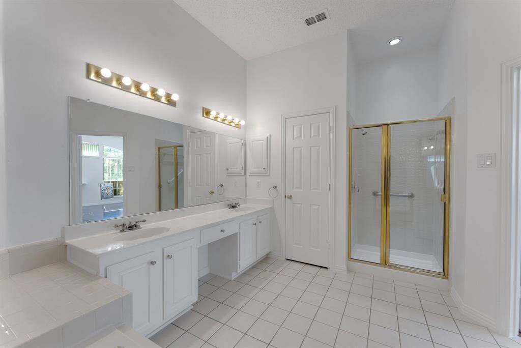 Charming brick home with large windows and a welcoming entrance, nestled between mature trees and well-maintained landscaping. Ideal for those seeking a blend of natural beauty and curb appeal.
