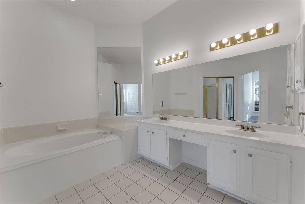 Charming brick home with large windows and a welcoming entrance, nestled between mature trees and well-maintained landscaping. Ideal for those seeking a blend of natural beauty and curb appeal.