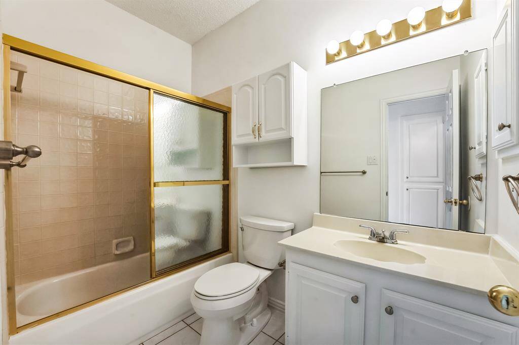 Charming brick home with large windows and a welcoming entrance, nestled between mature trees and well-maintained landscaping. Ideal for those seeking a blend of natural beauty and curb appeal.