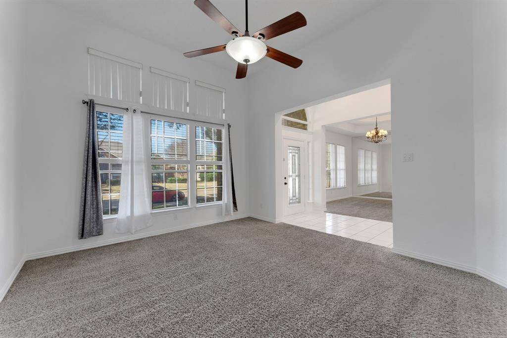 Charming brick home with large windows and a welcoming entrance, nestled between mature trees and well-maintained landscaping. Ideal for those seeking a blend of natural beauty and curb appeal.