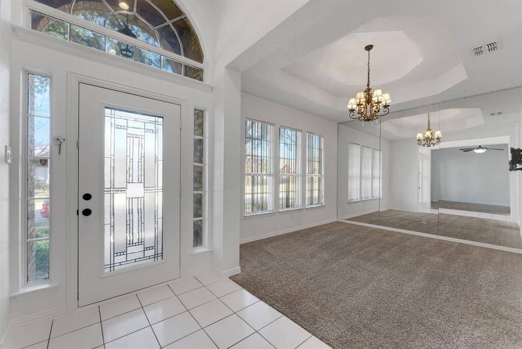 Charming brick home with large windows and a welcoming entrance, nestled between mature trees and well-maintained landscaping. Ideal for those seeking a blend of natural beauty and curb appeal.
