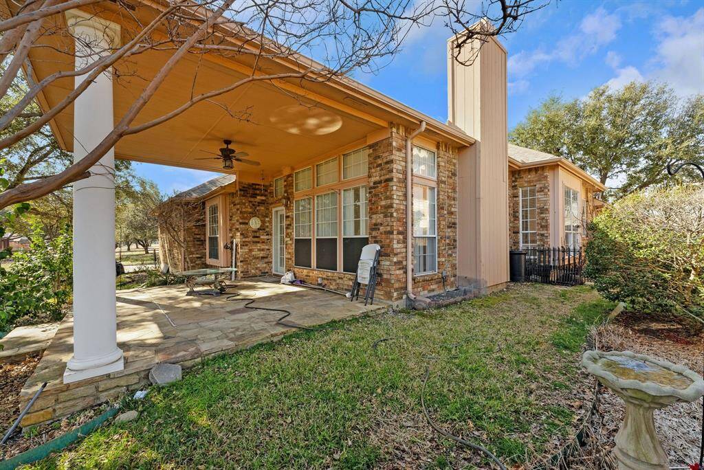 Charming brick home with large windows and a welcoming entrance, nestled between mature trees and well-maintained landscaping. Ideal for those seeking a blend of natural beauty and curb appeal.