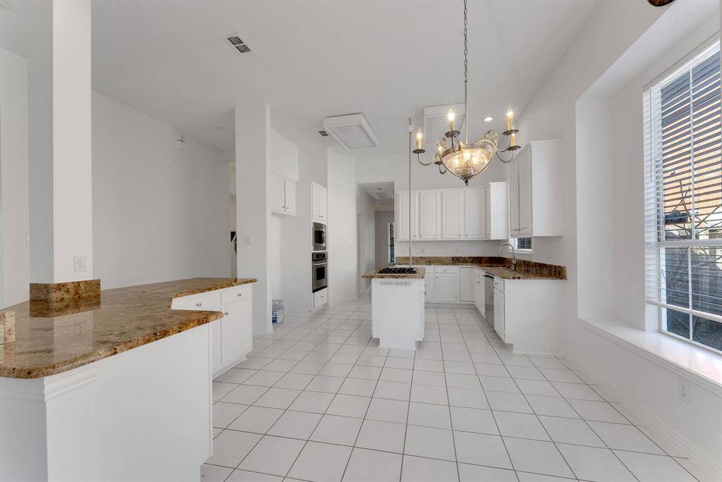 Charming brick home with large windows and a welcoming entrance, nestled between mature trees and well-maintained landscaping. Ideal for those seeking a blend of natural beauty and curb appeal.