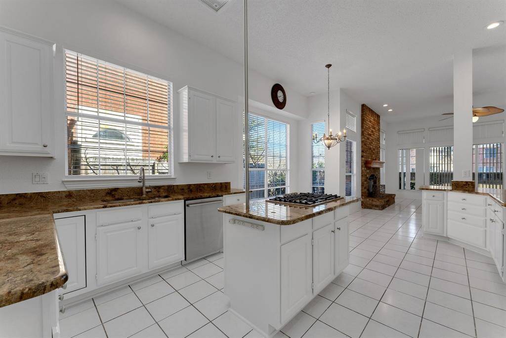 Charming brick home with large windows and a welcoming entrance, nestled between mature trees and well-maintained landscaping. Ideal for those seeking a blend of natural beauty and curb appeal.