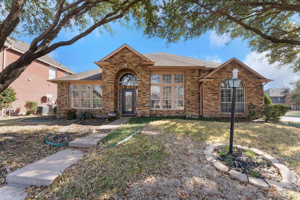 Charming brick home with large windows and a welcoming entrance, nestled between mature trees and well-maintained landscaping. Ideal for those seeking a blend of natural beauty and curb appeal.