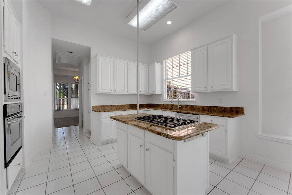 Charming brick home with large windows and a welcoming entrance, nestled between mature trees and well-maintained landscaping. Ideal for those seeking a blend of natural beauty and curb appeal.