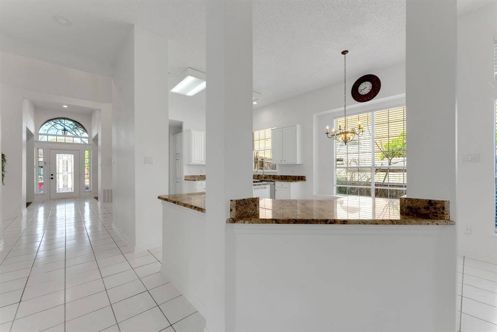 Charming brick home with large windows and a welcoming entrance, nestled between mature trees and well-maintained landscaping. Ideal for those seeking a blend of natural beauty and curb appeal.