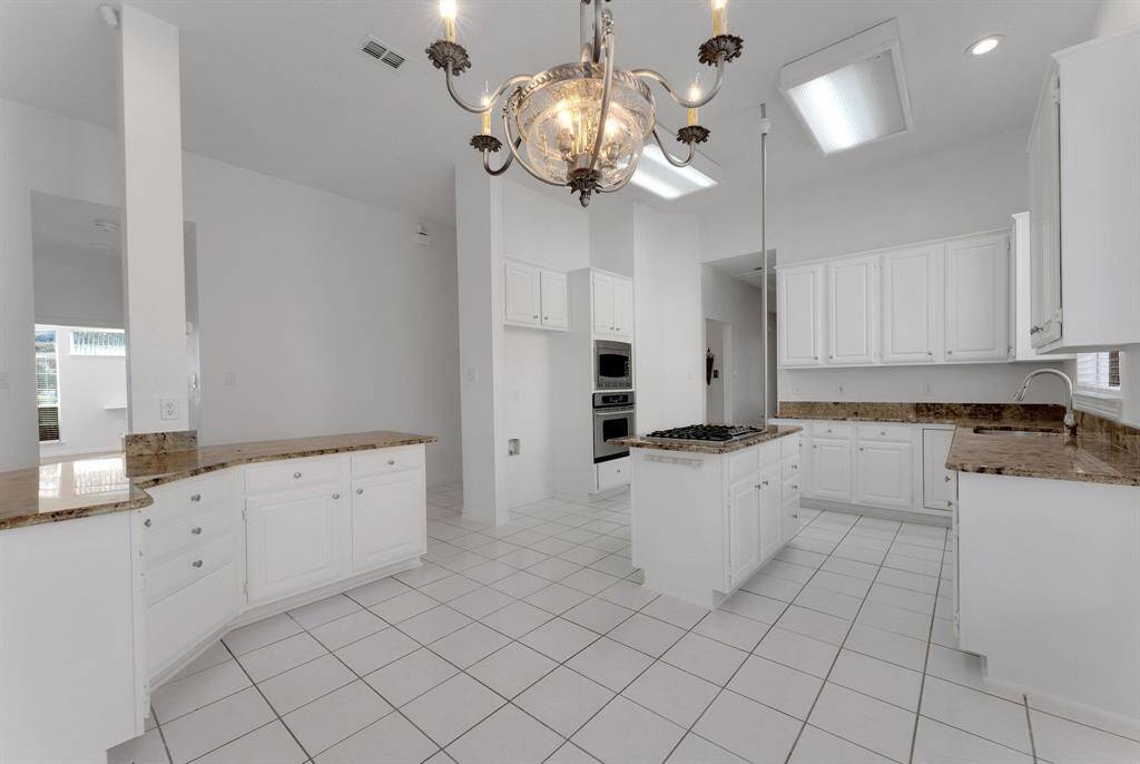 Charming brick home with large windows and a welcoming entrance, nestled between mature trees and well-maintained landscaping. Ideal for those seeking a blend of natural beauty and curb appeal.