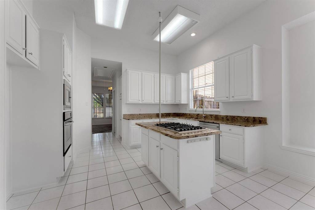 Charming brick home with large windows and a welcoming entrance, nestled between mature trees and well-maintained landscaping. Ideal for those seeking a blend of natural beauty and curb appeal.