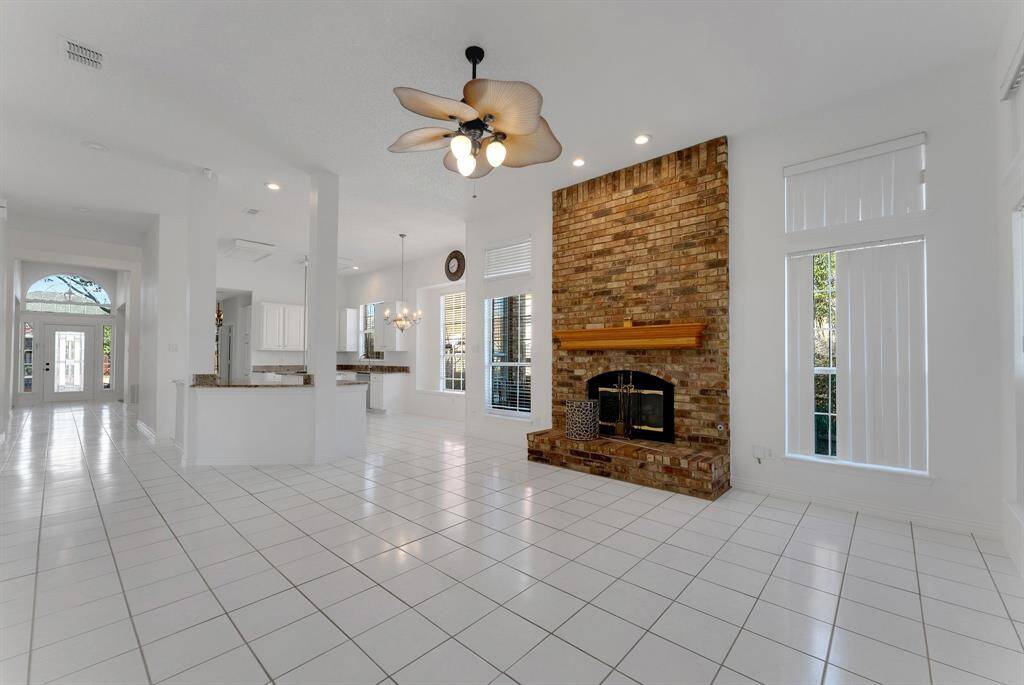 Charming brick home with large windows and a welcoming entrance, nestled between mature trees and well-maintained landscaping. Ideal for those seeking a blend of natural beauty and curb appeal.