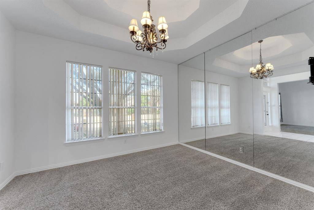 Charming brick home with large windows and a welcoming entrance, nestled between mature trees and well-maintained landscaping. Ideal for those seeking a blend of natural beauty and curb appeal.