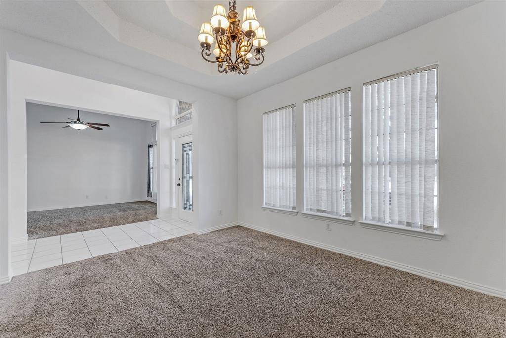 Charming brick home with large windows and a welcoming entrance, nestled between mature trees and well-maintained landscaping. Ideal for those seeking a blend of natural beauty and curb appeal.