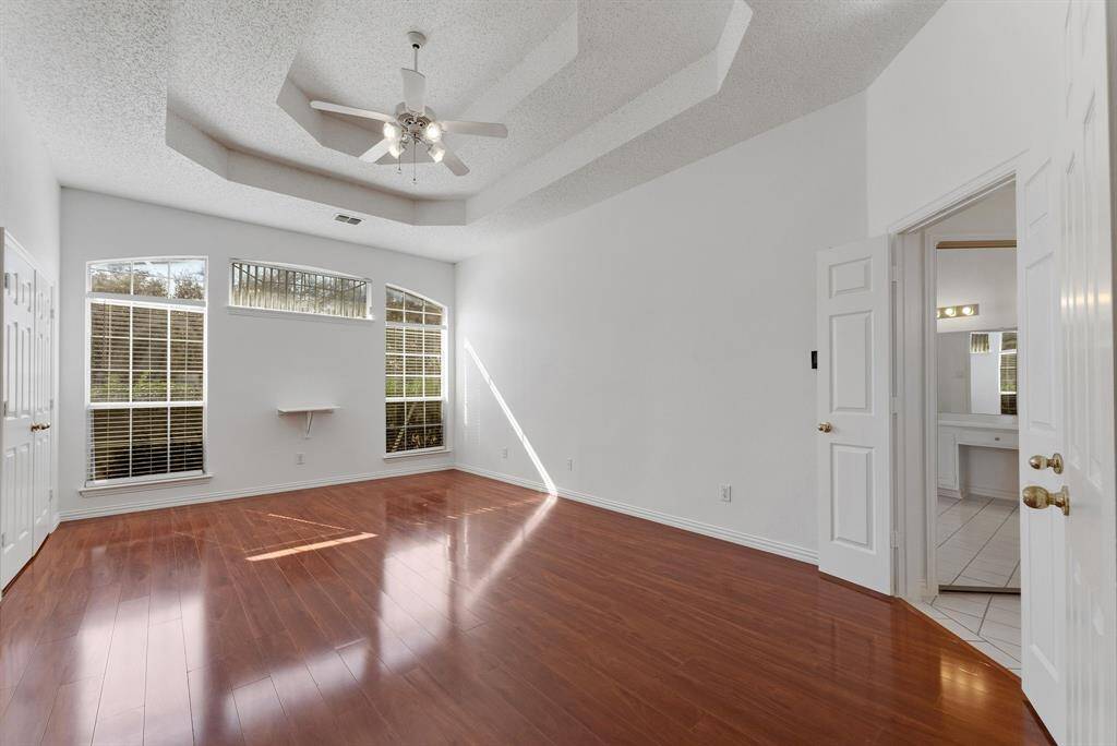 Charming brick home with large windows and a welcoming entrance, nestled between mature trees and well-maintained landscaping. Ideal for those seeking a blend of natural beauty and curb appeal.