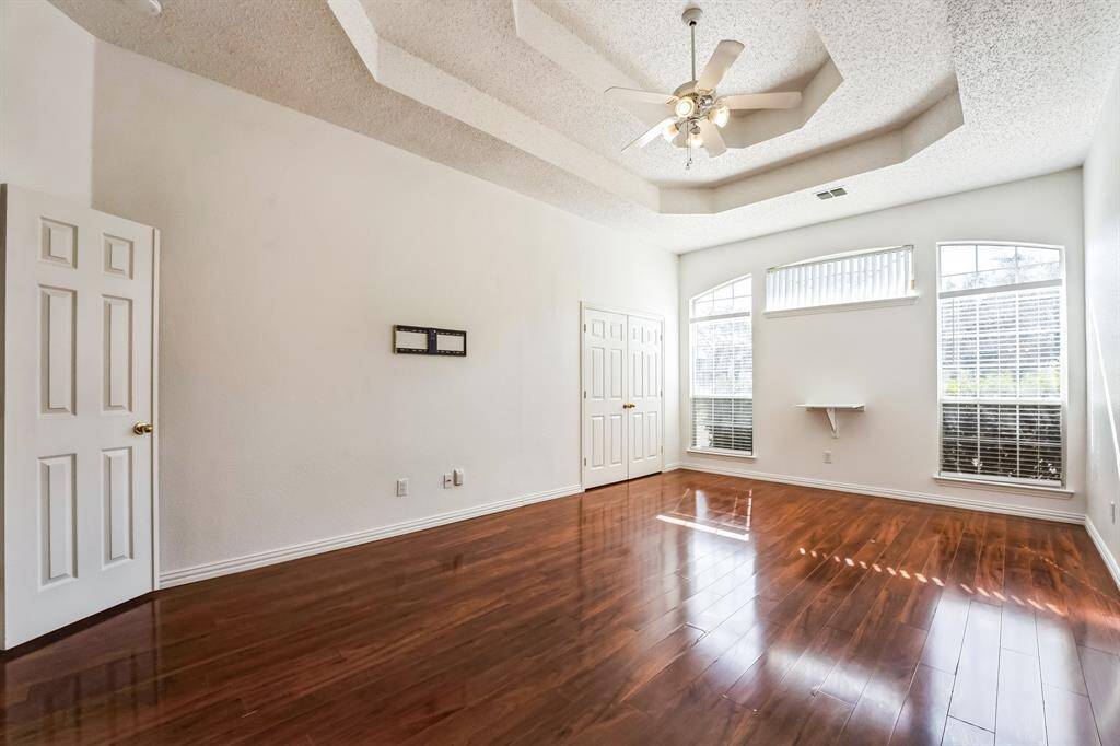 Charming brick home with large windows and a welcoming entrance, nestled between mature trees and well-maintained landscaping. Ideal for those seeking a blend of natural beauty and curb appeal.