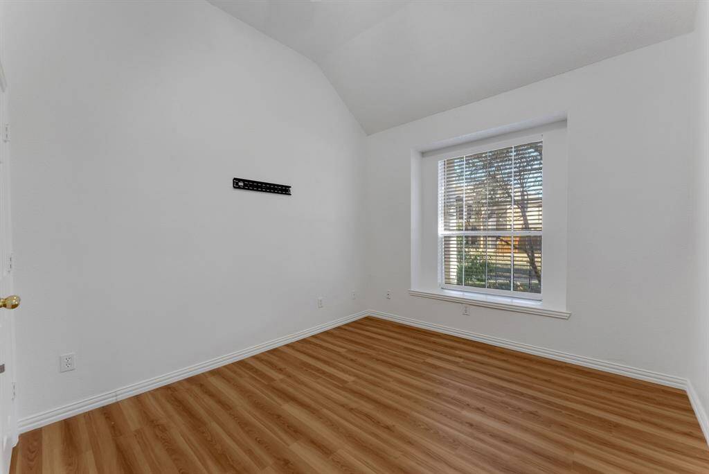 Charming brick home with large windows and a welcoming entrance, nestled between mature trees and well-maintained landscaping. Ideal for those seeking a blend of natural beauty and curb appeal.
