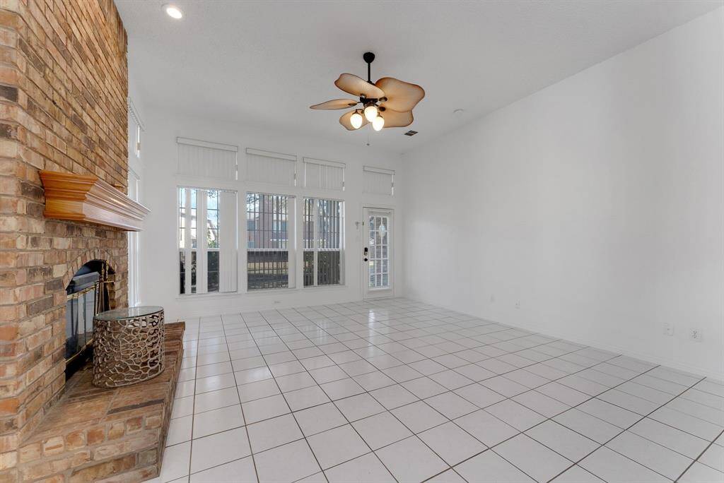 Charming brick home with large windows and a welcoming entrance, nestled between mature trees and well-maintained landscaping. Ideal for those seeking a blend of natural beauty and curb appeal.