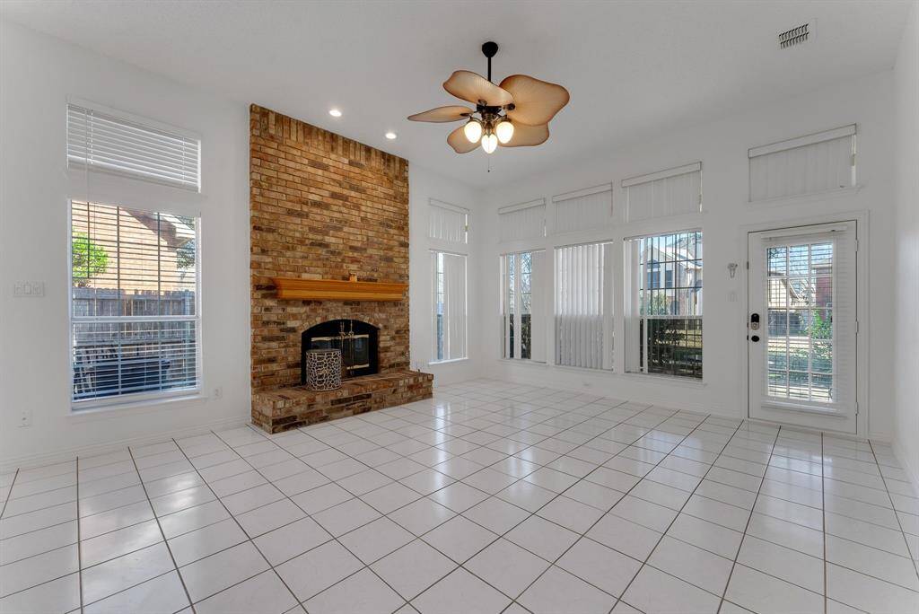 Charming brick home with large windows and a welcoming entrance, nestled between mature trees and well-maintained landscaping. Ideal for those seeking a blend of natural beauty and curb appeal.