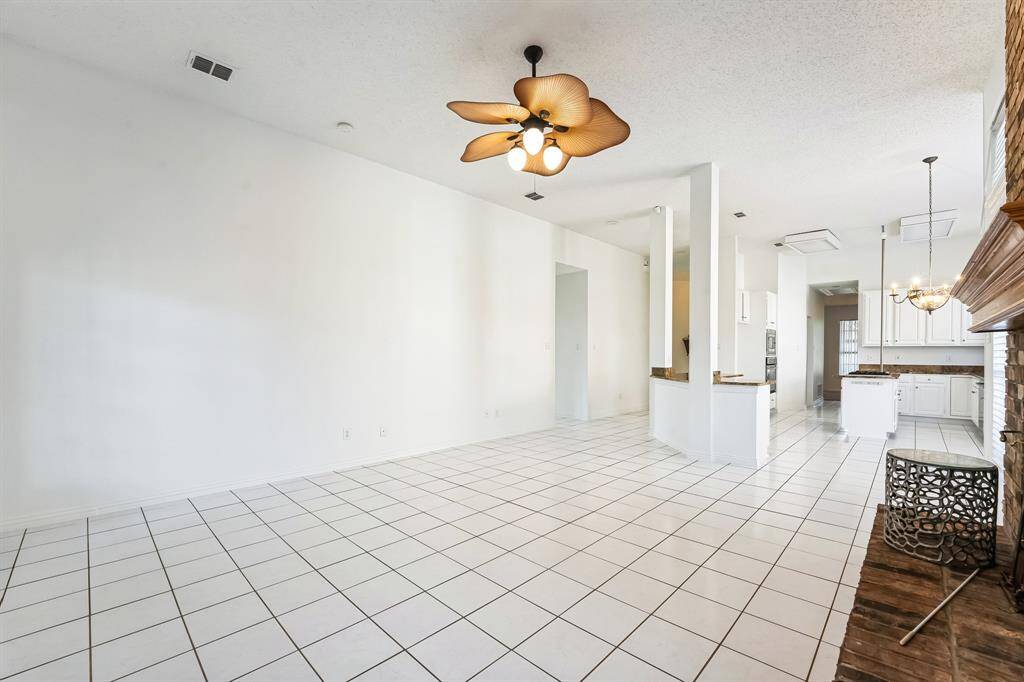 Charming brick home with large windows and a welcoming entrance, nestled between mature trees and well-maintained landscaping. Ideal for those seeking a blend of natural beauty and curb appeal.