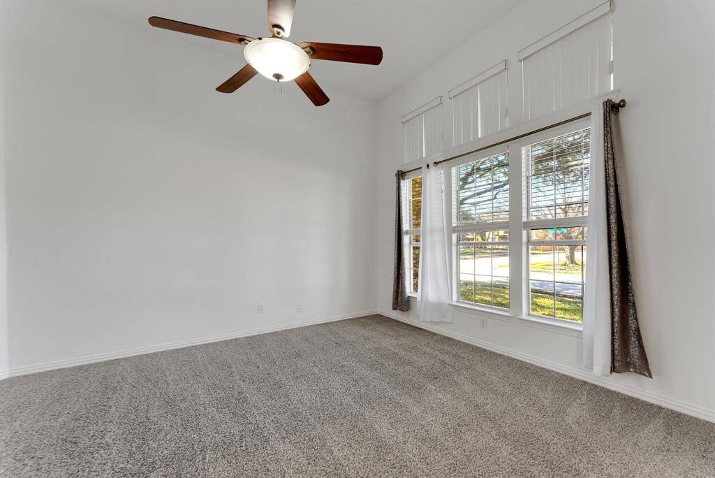 Charming brick home with large windows and a welcoming entrance, nestled between mature trees and well-maintained landscaping. Ideal for those seeking a blend of natural beauty and curb appeal.