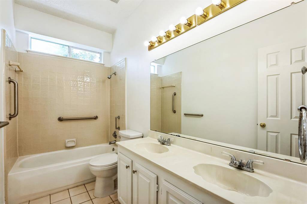 Charming brick home with large windows and a welcoming entrance, nestled between mature trees and well-maintained landscaping. Ideal for those seeking a blend of natural beauty and curb appeal.