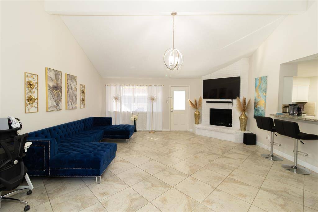 Spacious living room with high ceilings and tiled floors.