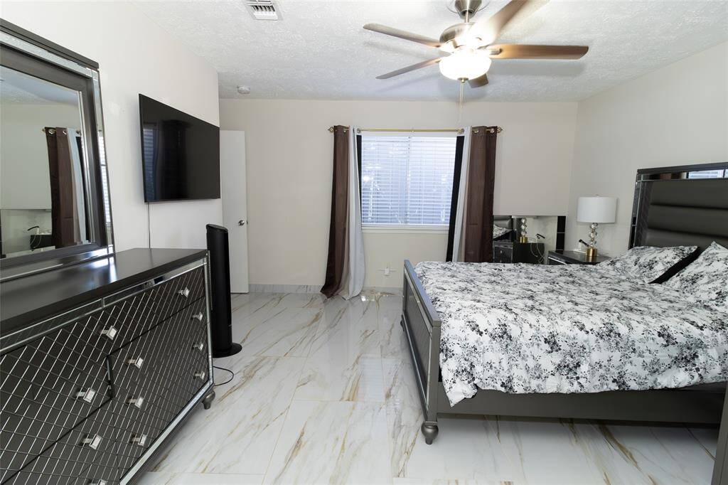 The room is bright with natural light from a window, complemented by neutral walls and tiled flooring.