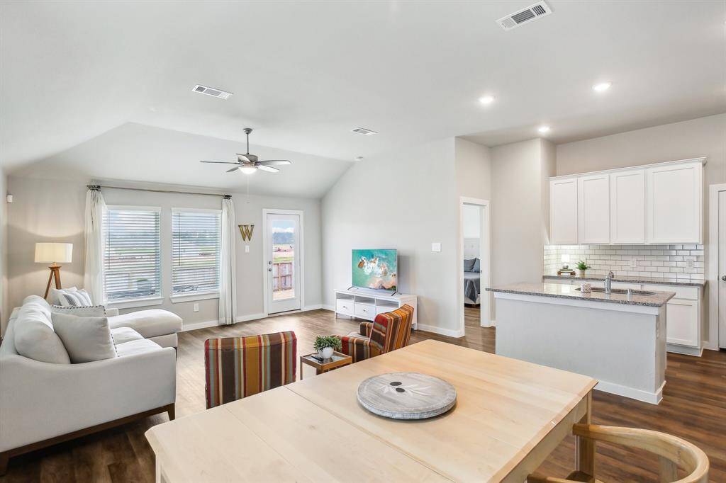Open space that flows from dining to living to kitchen to primary bedroom.
