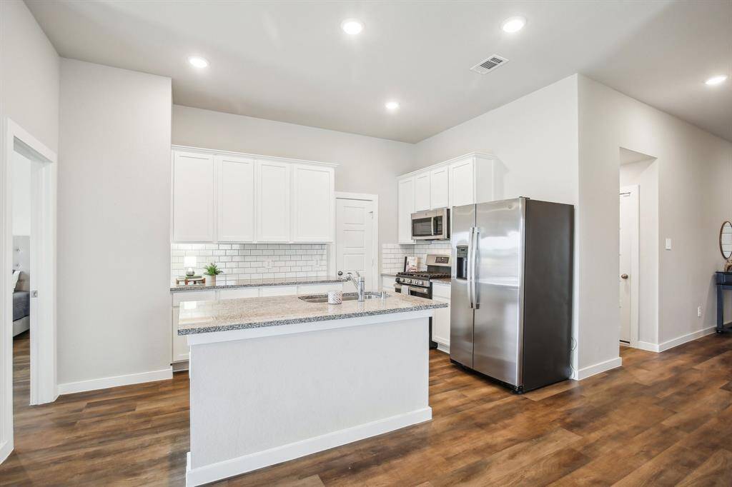 Super cute kitchen with modern appliances, subway tile backsplash and bright white cabinetry.