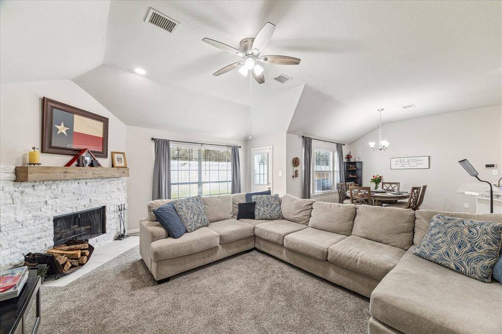 Cozy stone fireplace and abundant natural light enhance comfort and warmth.