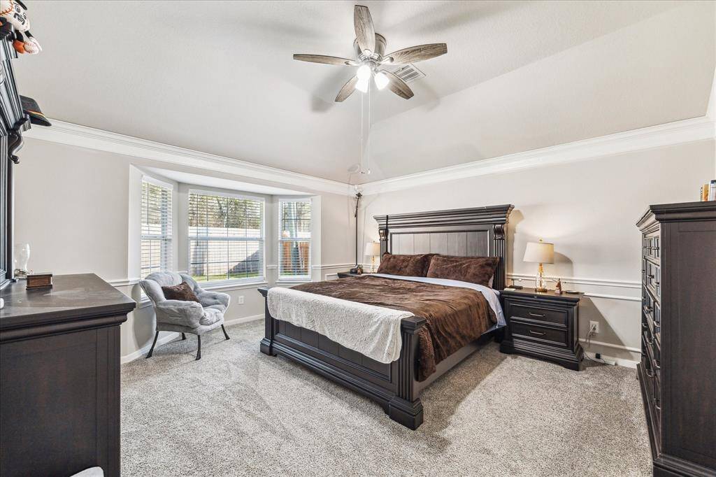 Spacious primary bedroom featuring a bay window with serene backyard views.