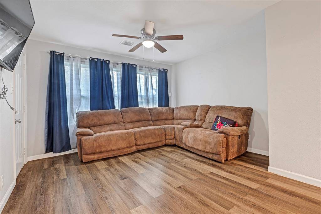 The living room features beautiful wooden floors, offering a versatile space that you can easily style to suit your personal taste.