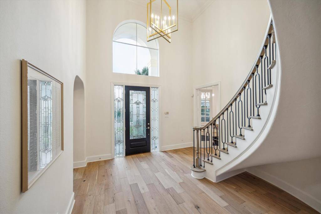 The spacious foyer with soaring ceilings and sweeping staircase punctuates the remarkable quality of this spectacular residence with its continuously French Oak wood flooring that flows continuously throughout the first floor. The foyer front windows bathes the entrance with pleasing natural light, and it is flanked by both sides by a private study-library and formal dining room.