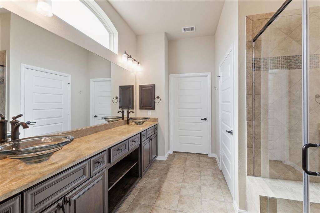 The oversized shower has beautiful decorative tile accent and built in bench.  There is a good sized walk in closet and water closet.