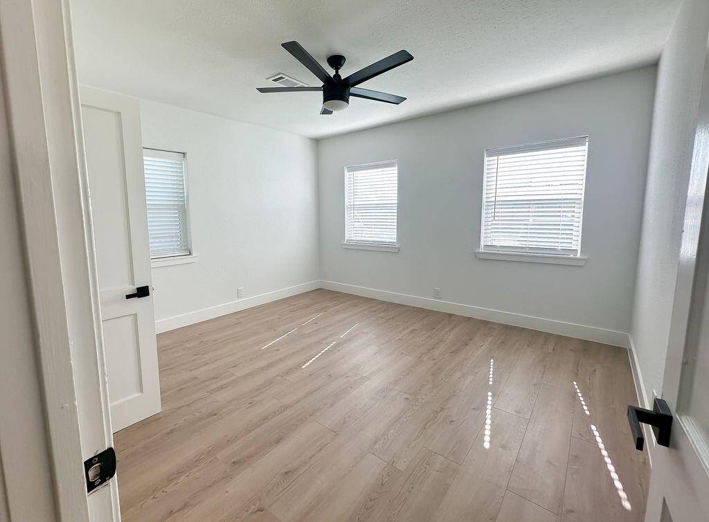 Bright bedroom with two large windows, offering ample natural light and plenty of space.