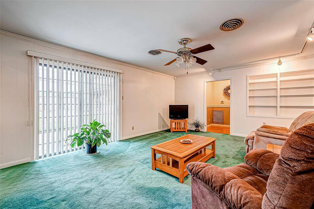 This alternate view of the family room highlights its spaciousness and natural light, creating an inviting and adaptable space for relaxation or entertaining. The large sliding glass doors not only bring in abundant sunlight but also provide seamless access to the outdoor area, perfect for enjoying fresh air or extending gatherings to a patio or backyard.