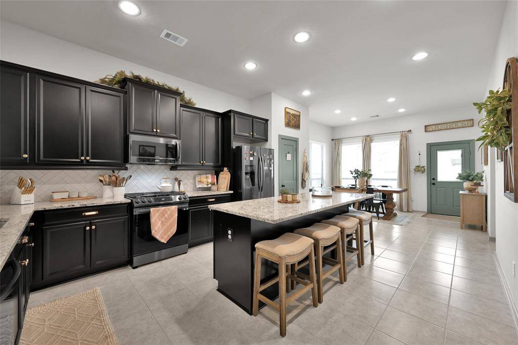 This is a spacious, modern kitchenwith large island and bar seating.