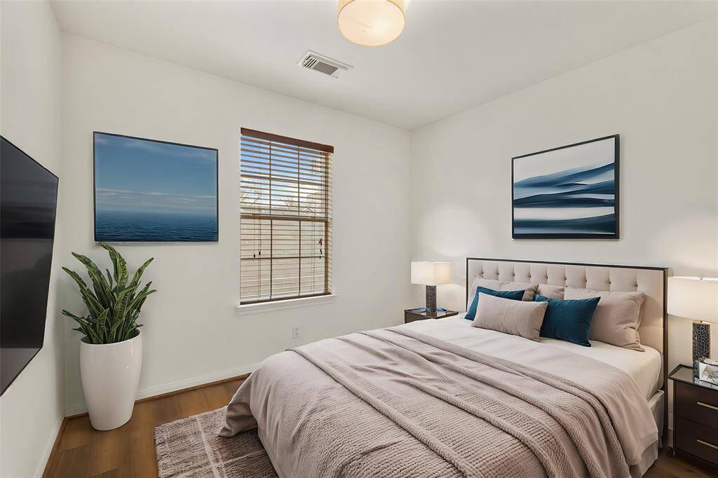 Virtually Staged: This lovely secondary bedroom features neutral colors, wood floors, and a window with privacy blinds.