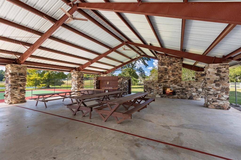 Outdoor pavilion with hitching posts for horses, kitchen and wood burning fireplace.