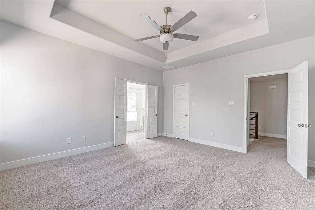 Now THIS is a primary bedroom! Just check out the plush neutral carpet, ceiling fan, and tray ceiling.