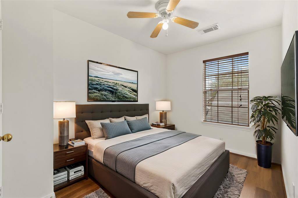 Virtually Staged: This lovely secondary bedroom features neutral colors, wood floors, a ceiling fan, and a window with privacy blinds.