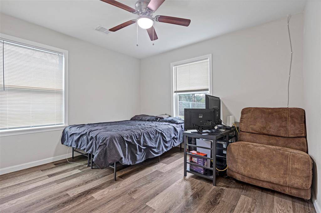 One of the secondary rooms, featuring large windows that fill the space with natural light, along with a ceiling fan for added comfort.