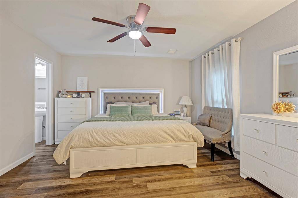 Step into the main bedroom, featuring elegant wooden floors and an en-suite bathroom for added convenience and privacy.