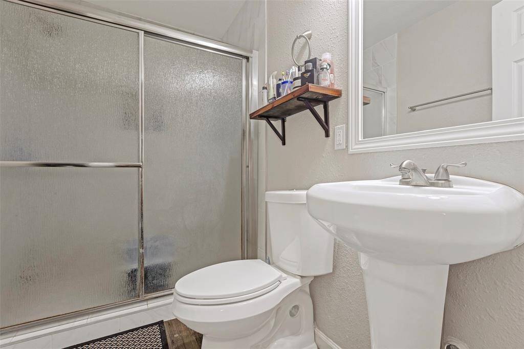 This main bathroom features a tub and shower combo, along with a single sink, offering both functionality and comfort.