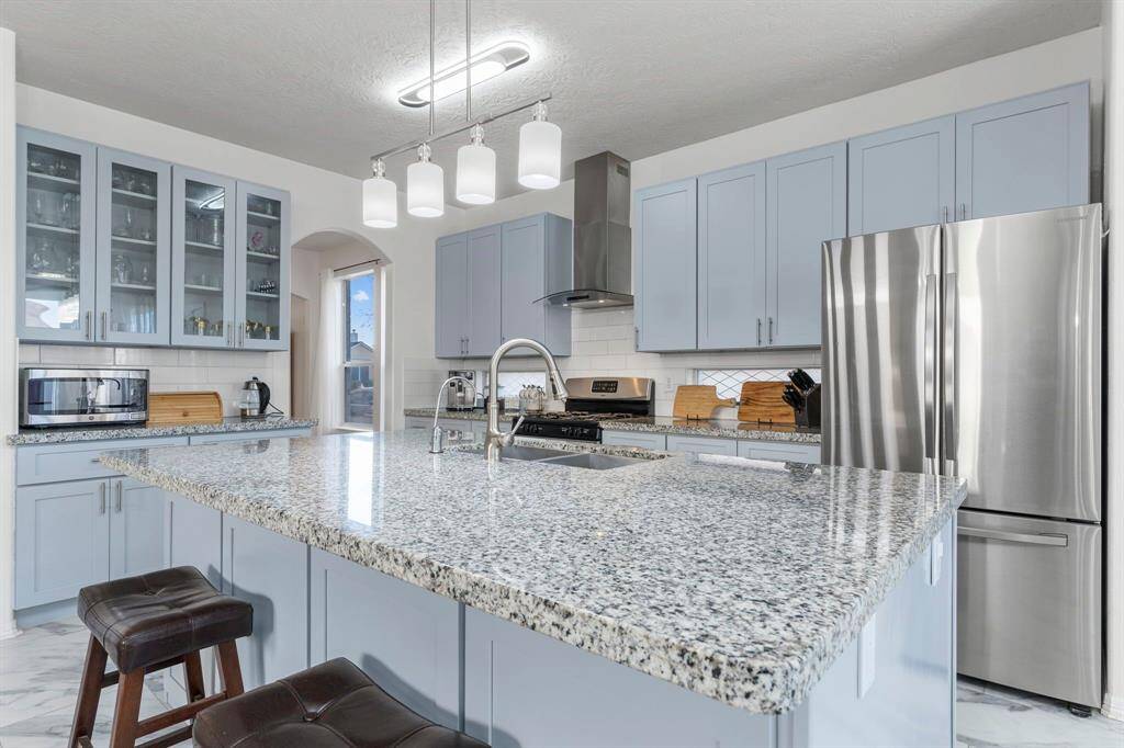 Check out the attention to detail beneath the island! It features a deep custom stainless steel undermount sink, a pull-out swan kitchen faucet, a water filtration system, and more!