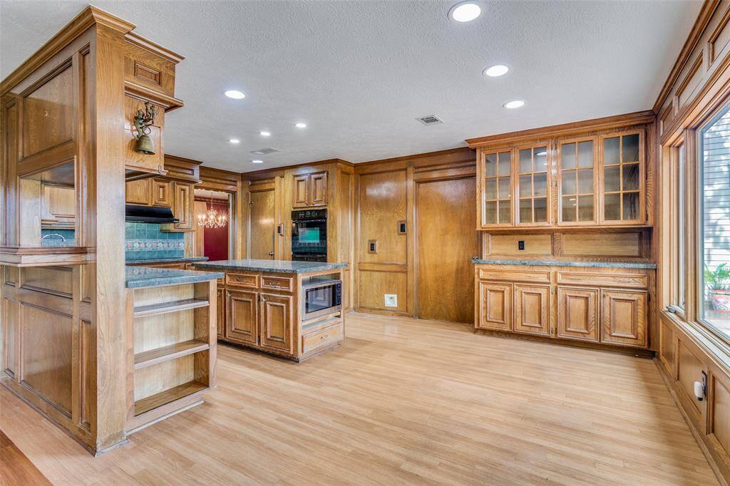 There are end cap bookcases in kitchen. The utility room and powder room are located off of the kitchen, There is a large walk-in pantry which also has a built-in space rack on the door.
