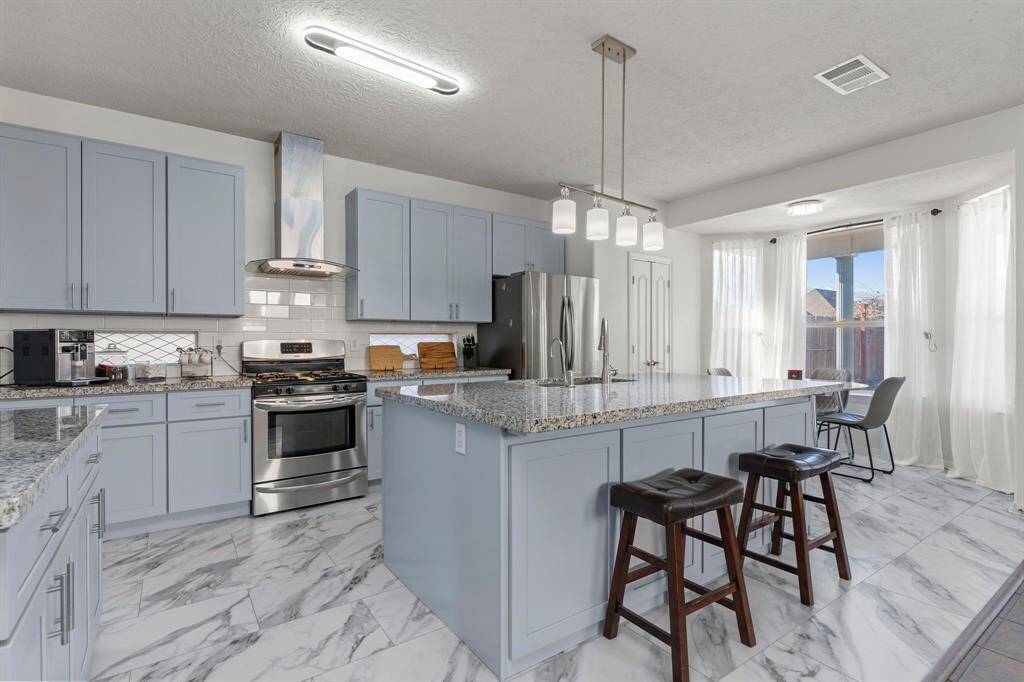 Tall custom shaker cabinets paired with a chic subway tile backsplash that perfectly complements the stunning tile floors!