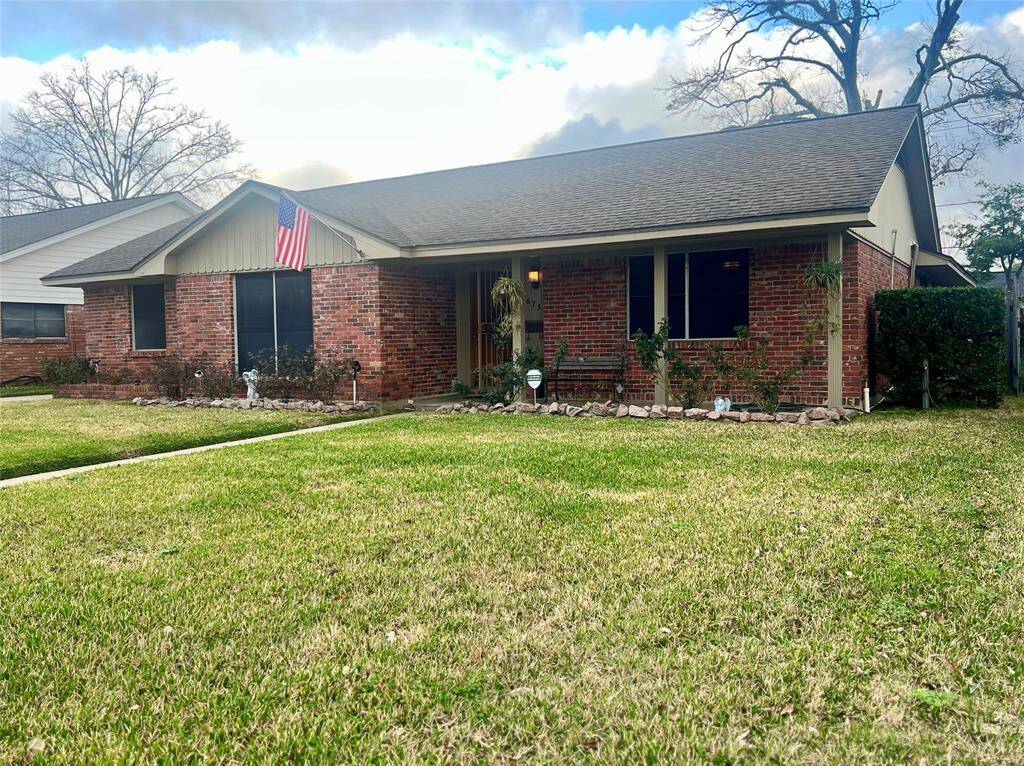 Charming single-story brick home with a manicured lawn and a welcoming front porch. The property features a paved walkway and mature landscaping, offering great curb appeal in a quiet neighborhood.