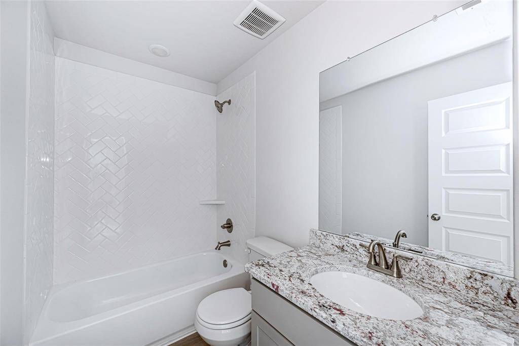 The secondary bathroom offers that same gorgeous granite in the kitchen. The specks of purple really make it pop and elevate the look and feel of this delightful retreat!